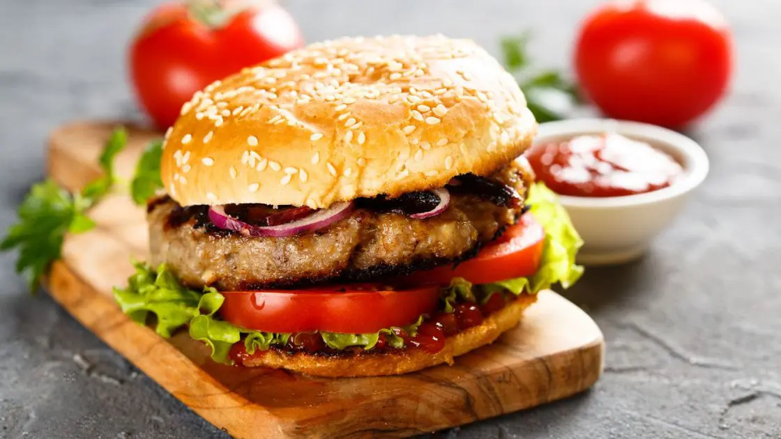 air fryer greek lamb burger in a roll with salad